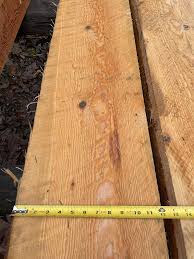 Rough sawn doug fir lumber 2x12 with measuring tape, showcasing natural wood grain and structural quality.